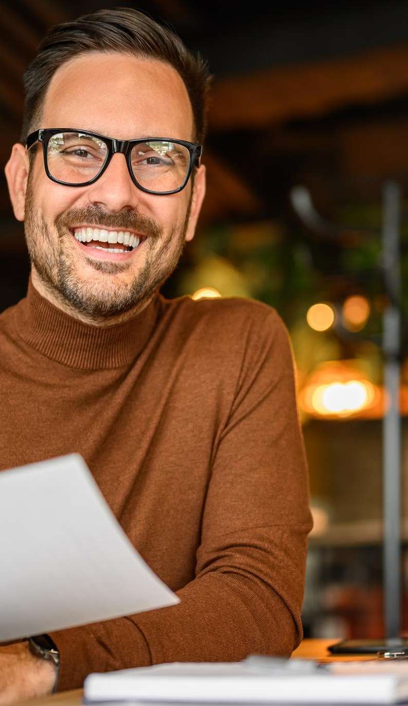 man in brown sweater smiling